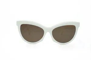 White frame cat eye sunglasses detail view, trendy retro eyewear with brown tinted lenses.