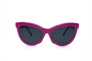 Chunky pink cat-eye sunglasses detail showcasing retro style, thick frame, and dark lenses.