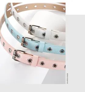 Dettaglio delle cinture alla moda in pelle PU per bambini con occhielli metallici e fibbie.