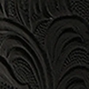 Close-up detail of black embossed leather belt featuring intricate vintage floral pattern.