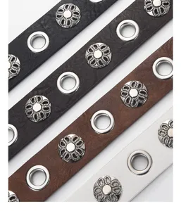 Detailed view of punk style leather belt with metal eyelets and floral studs, fashionable.