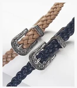 Detailed close-up of vintage braided leather belts with ornate engraved silver metal western buckles.