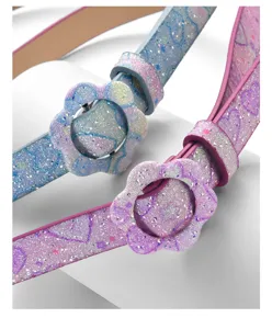 Primo piano cintura bambini con fibbia a fiore glitterata, design rosa e blu brillante.
