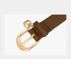 Close-up detail of brown PU leather women belt featuring stylish gold buckle and heart charm.