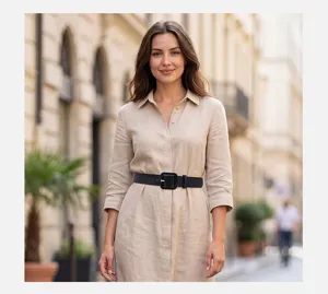Detailed view of the stylish wide black belt paired with a beige linen shirt dress outdoors.