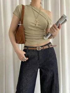 Close-up detail shot of the minimalist brown thin waist belt styled with dark denim jeans.