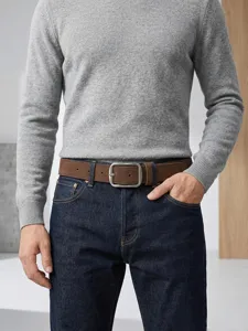 Detailansicht eines braunen Wildlederimitat Gürtels mit edler Schnalle zu klassischer Jeans.