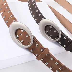 Close-up detail of retro suede rivet women's belt with oval metal buckle and double studs.