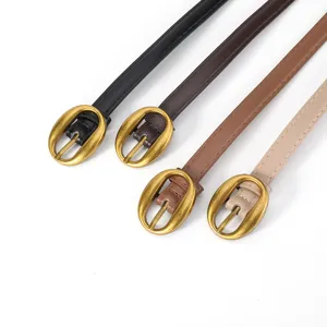 Détail en gros plan de fines ceintures vintage pour femmes avec boucles ovales dorées et rétro.