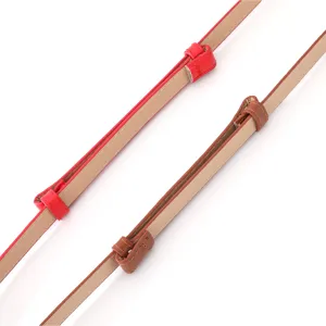 Close-up detail of adjustable thin leather belts for women, showing buckle and strap loops.