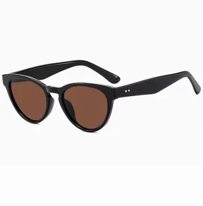 Detalle gafas de sol cat-eye montura negra, lentes marrones rétro, estilo chic