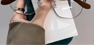 Primer plano de gafas retro de media montura con marco metálico y patillas de madera.