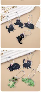 Close-up detail shot of cute cartoon black cat and crocodile acrylic keychains with bead chains.