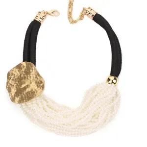 Détail du collier de perles multicouches avec plaque en métal doré martelé et cordon noir