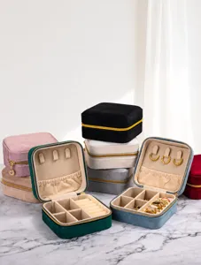 Opened velvet jewelry organizer box with rings and earrings displayed inside