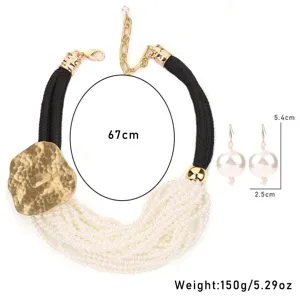 Détail d'un collier de perles multicouches avec plaque en métal martelé doré et poids.