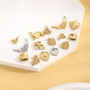 Nahaufnahme von herz- und flügelförmigen Edelstahl-Anhängern in Gold und Silber.