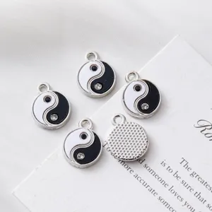 Detailed macro shot of Yin Yang Taiji charms with black white enamel and crystals for DIY