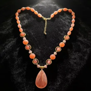 Detailed view of handmade resin beaded necklace with orange water-drop pendant