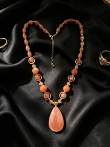 Macro detail of dopamine style handmade resin beaded necklace featuring a large teardrop pendant