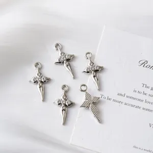 Macro view of silver-plated cross pendants with inlaid rhinestones for DIY jewelry