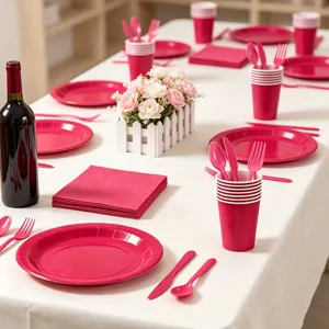 Conjunto de vajilla de fiesta desechable rosa con platos de papel vasos servilletas y cubiertos.