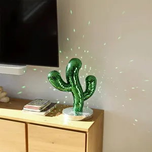 Green mosaic cactus disco ball detail shot showing shimmering light reflections on the wall.