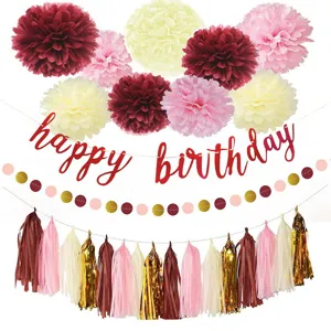 Birthday party decoration set with paper pom poms, happy birthday banner and tassels.
