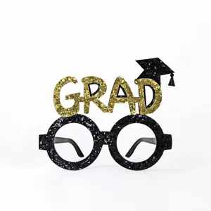 Black and gold graduation party eyeglasses photo booth prop with grad letters and cap design.