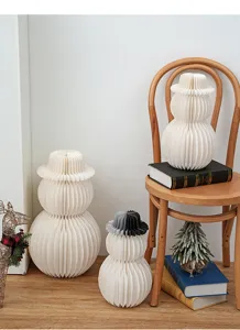 White paper honeycomb snowman ornaments for Christmas winter holiday home decor window display.