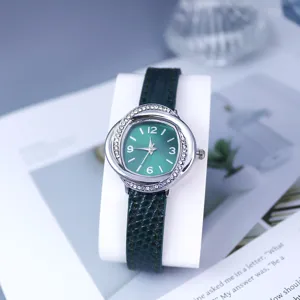 Elegant women quartz watch detail, green dial with sparkling rhinestones, stylish leather strap.
