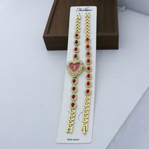 Vue détaillée de la montre quartz cœur doré et du bracelet de strass assorti en gros plan.