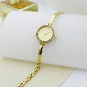 Close-up of luxury gold quartz bracelet watch featuring a sparkling rhinestone bezel and sleek strap.