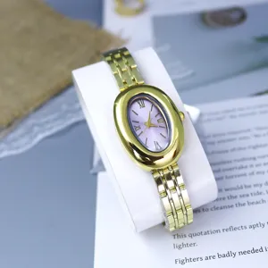 Elegant oval vintage women gold watch with purple dial and stylish steel strap accessory.