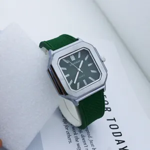 Detalle en primer plano de reloj de cuarzo cuadrado retro para hombre con correa de silicona verde.