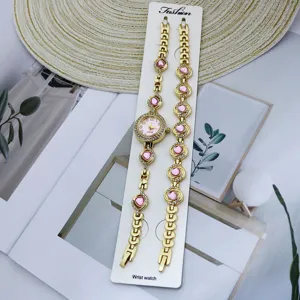 Ensemble montre quartz et bracelet pour femme avec cadran rose et strass brillants.
