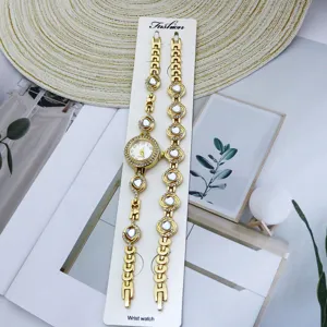 Vue détaillée de l'ensemble montre quartz et bracelet strass dorés, design élégant.