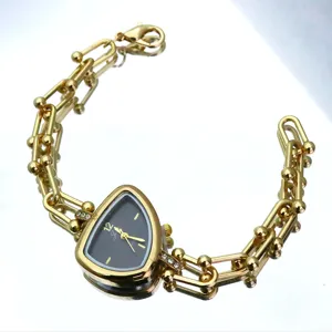 Goudkleurig quartz horloge met unieke driehoekige wijzerplaat en opvallende schakelarmband.