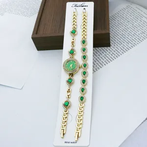 Detailansicht des goldenen Damen Quarzuhr und Armband Sets mit gruenen Steinen und Ziersteinen.