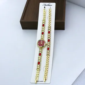 Damen Quarzuhr und Armband Set, goldfarben mit roten Kristallen und Strasssteinen.