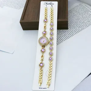 Goldenes Quarz Modeuhr und Armband Set für Damen mit lila Kristall Strass Details.