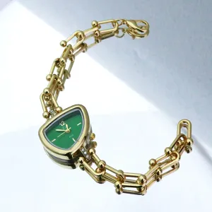 Gedetailleerd overzicht dames horloge kwarts met groene driehoek wijzerplaat gouden band.
