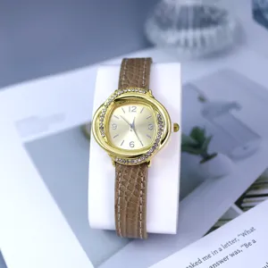 Women fashion rhinestone quartz watch with brown leather strap and golden dial details.