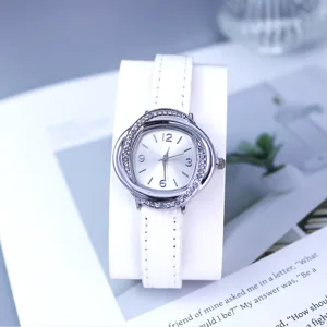 Detail shot of elegant women quartz watch with white leather strap and rhinestone bezel.
