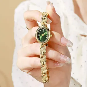 Élégante montre quartz rétro pour femme avec cadran vert oval et bracelet chaîne doré fin.