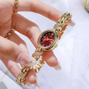 Gros plan détail de montre quartz femme ovale rétro avec cadran rouge et bracelet doré sculpté.