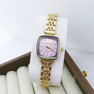 Montre quartz femme compacte avec cadran rose carré et bracelet en métal doré élégant.