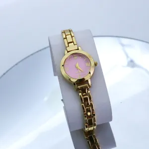Dettaglio orologio da polso donna dorato con elegante quadrante rosa e cinturino metallico.