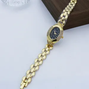 Reloj de cuarzo ovalado vintage con pedrería, esfera negra y pulsera de cadena metálica elegante.