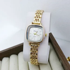 Gros plan détaillé d'une petite montre à quartz dorée carrée pour femme avec bracelet métallique.